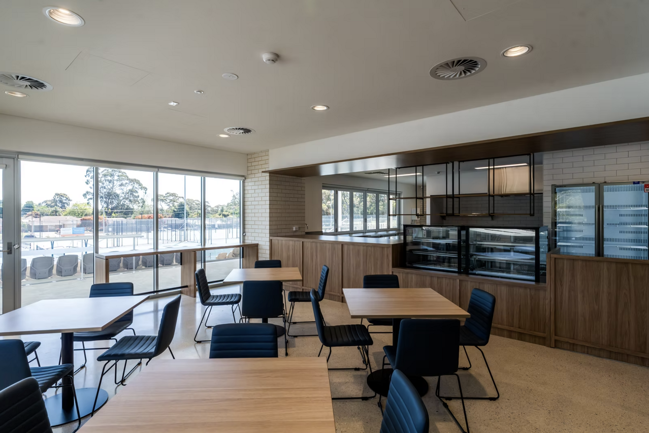The clubhouse cafe, with tables set beside a window looking out over the courts