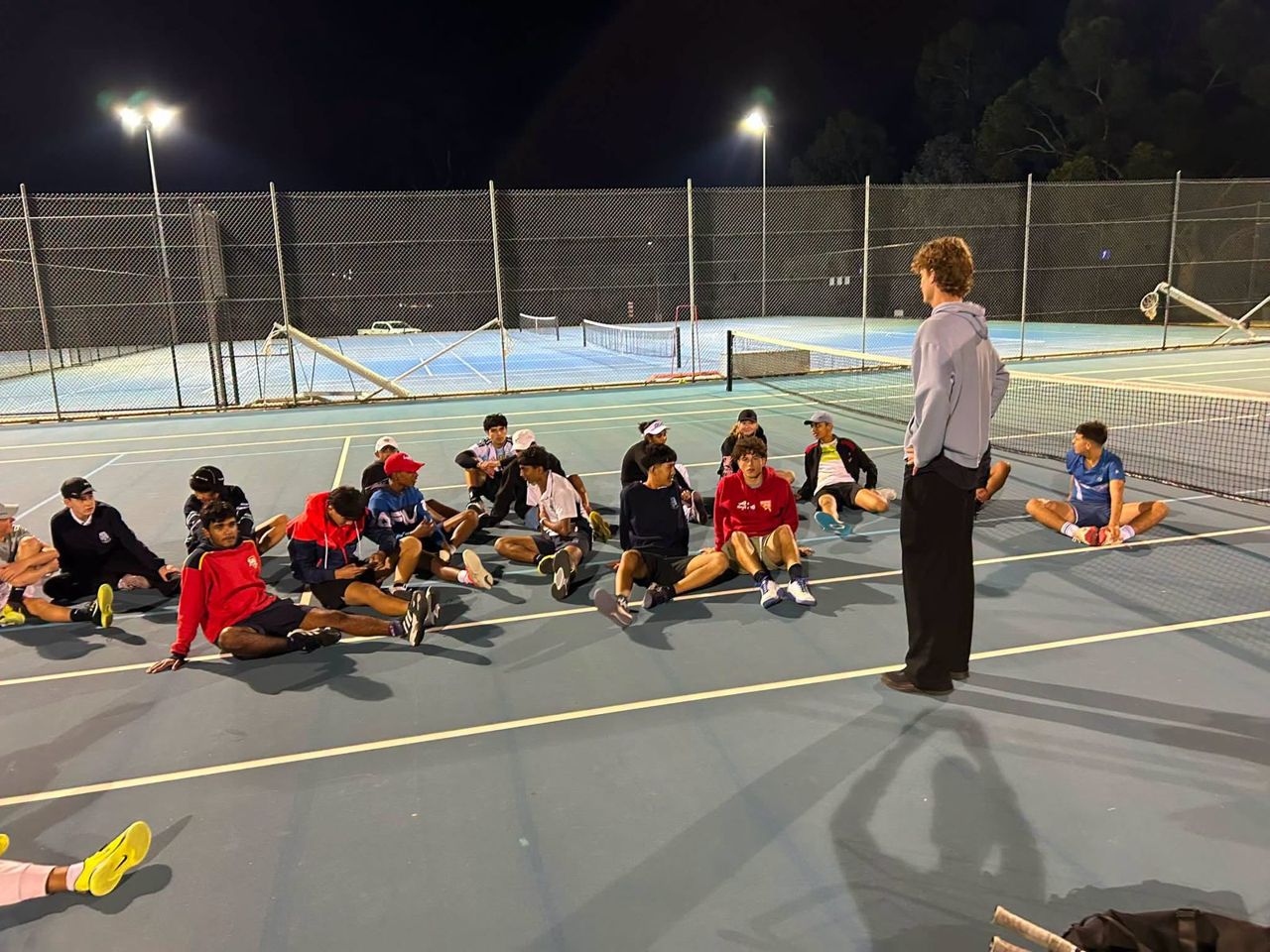 The squad gathered on court for a briefing during an evening session